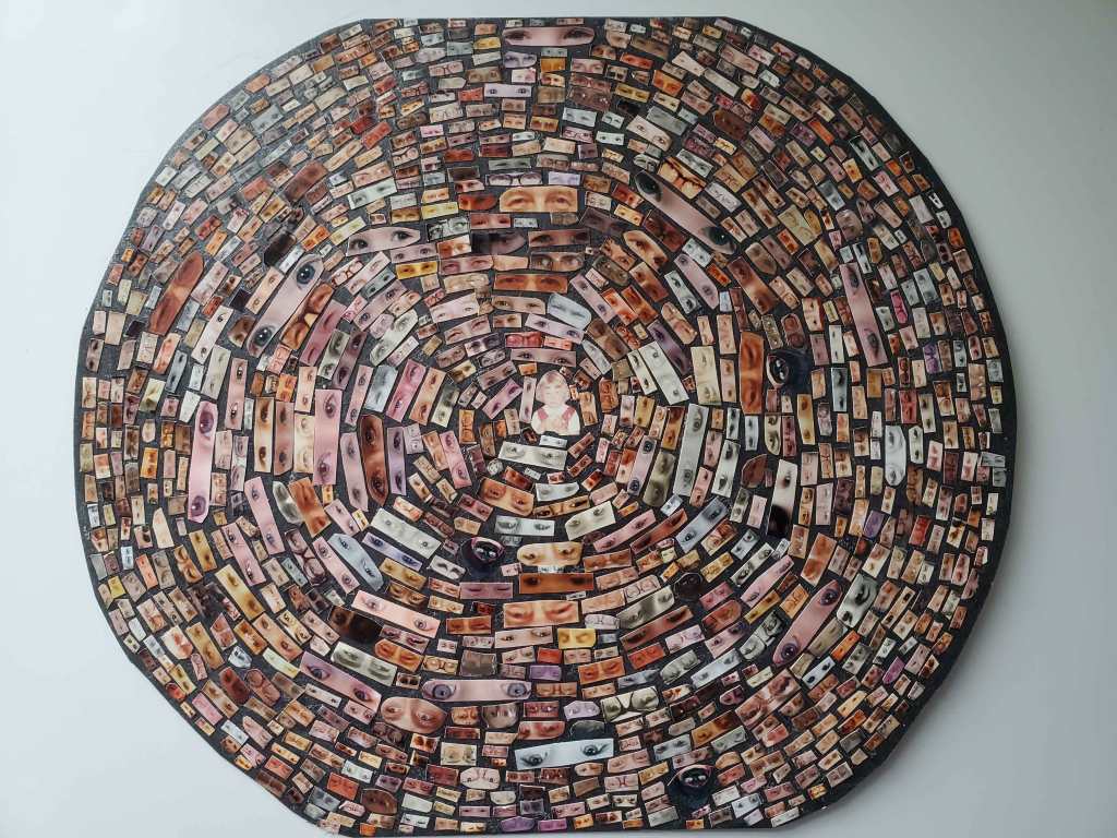 A spiral of images from magazines of people's eyes, with a photo of a young girl in the middle of it.